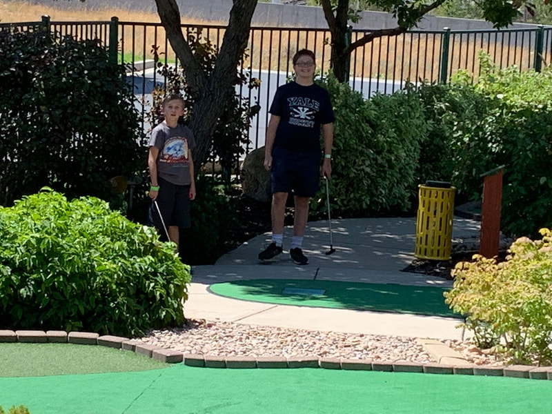 two youths playing mini golf