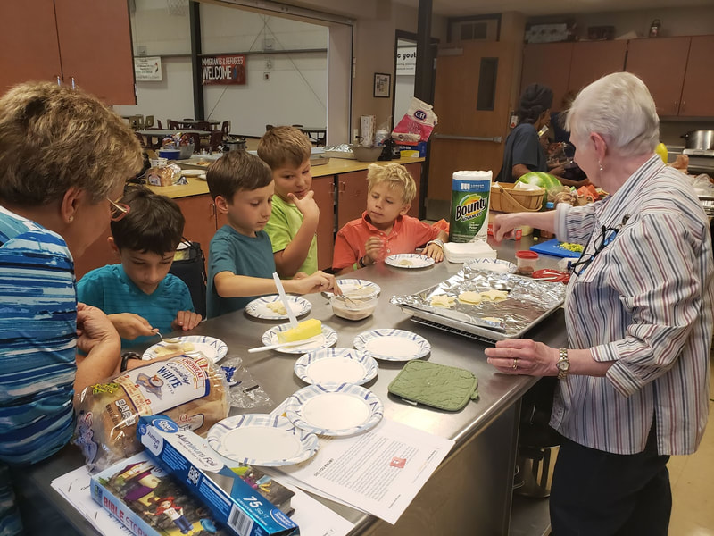 a group of children and adults making cookies