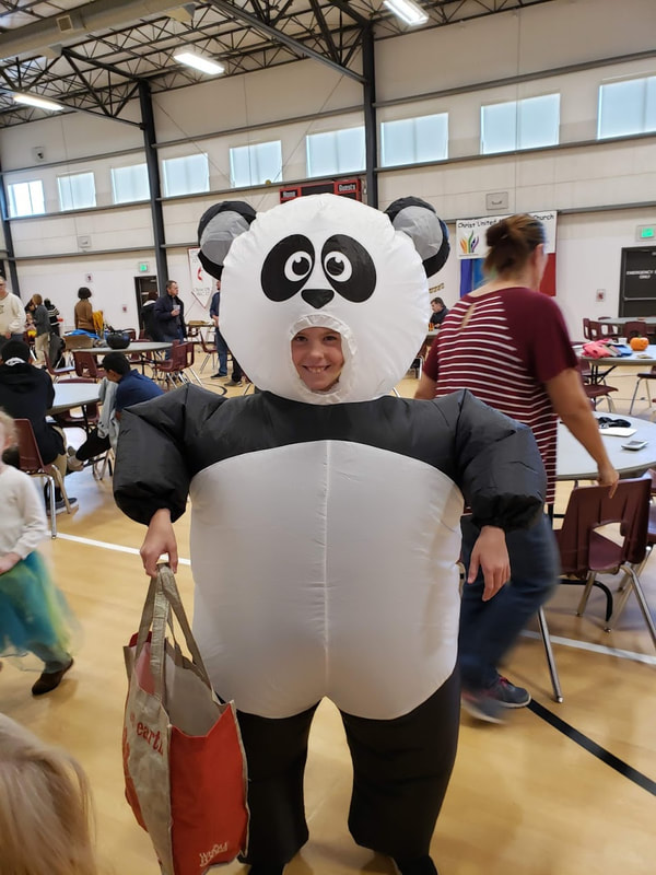 a smiling child in a panda costume